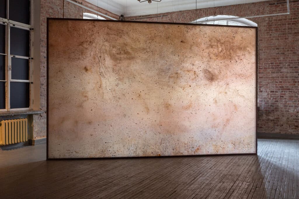 a large art piece with shades of brown in a gallery